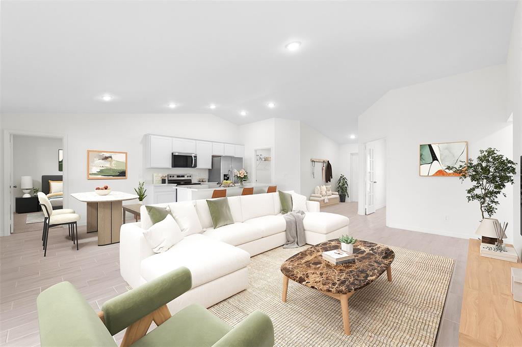 A bright, open-concept living room features a white sectional sofa, dining area, and modern kitchen — 3510 E ELIAS CIRCLE, NORTH PORT, FL