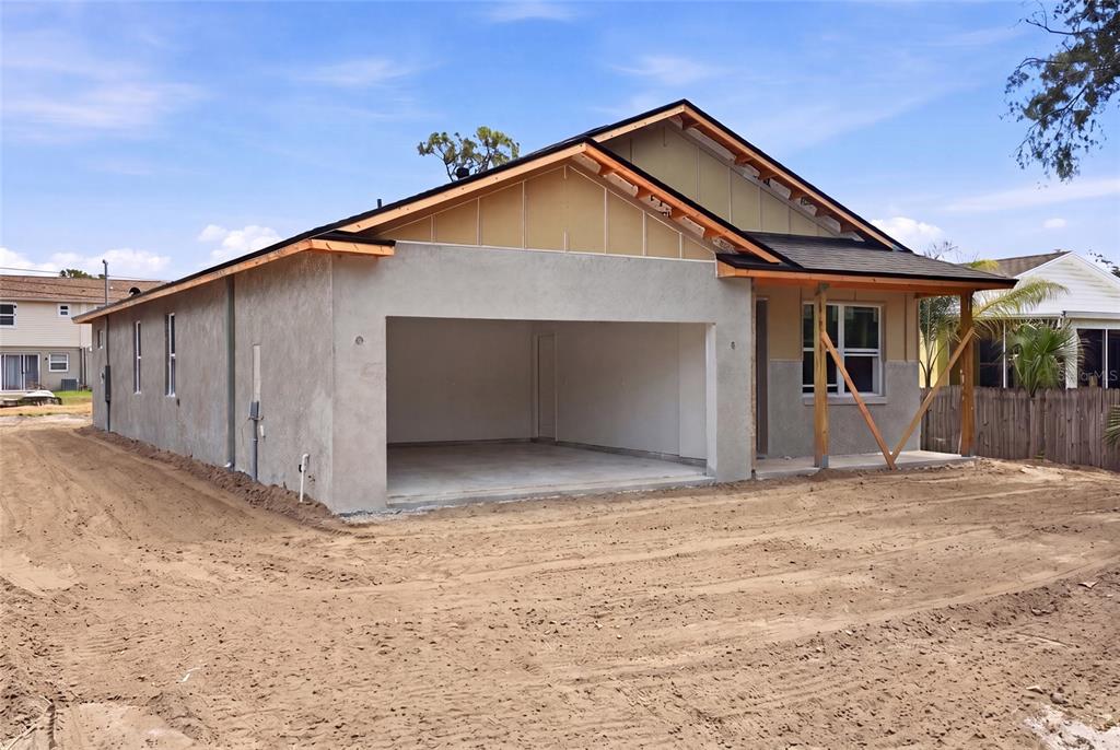 An exterior view of a house under construction with an open garage and unfinished siding — 2139 20TH AVENUE SW, LARGO, FL