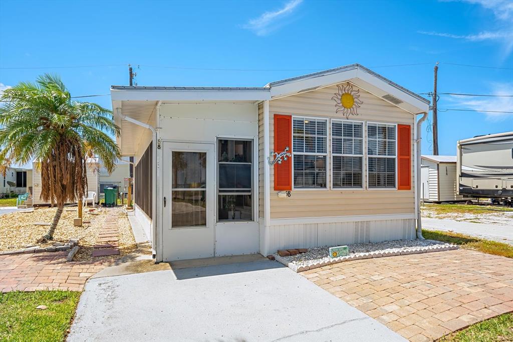 An aerial view shows a mobile home community situated along a waterfront with palm trees — 58 MONTEGO DRIVE, PALMETTO, FL