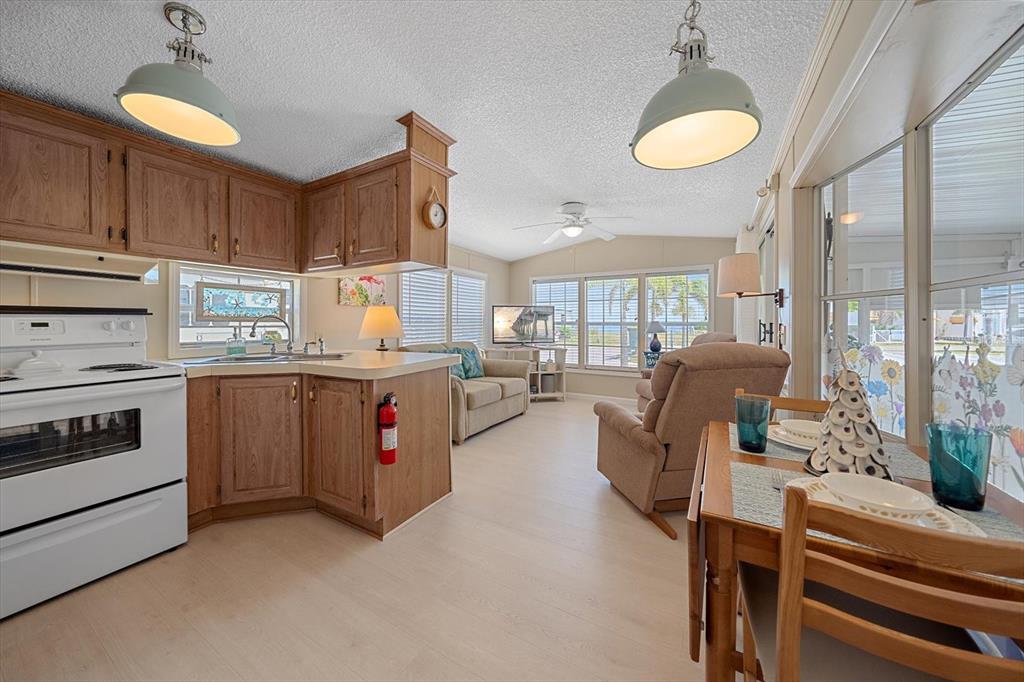 A single-story manufactured home with tan siding, orange shutters, and a front concrete patio — 58 MONTEGO DRIVE, PALMETTO, FL