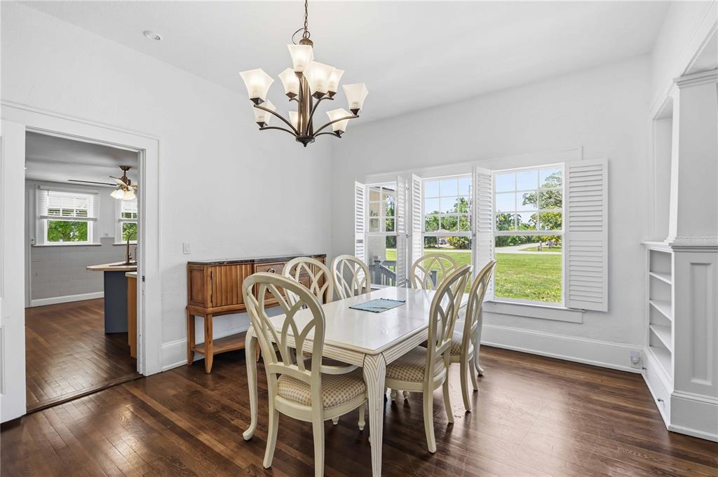 A dining room features a wooden table, six chairs, a chandelier, and hardwood floors — 815 SOLONA LOOP, PUNTA GORDA, FL