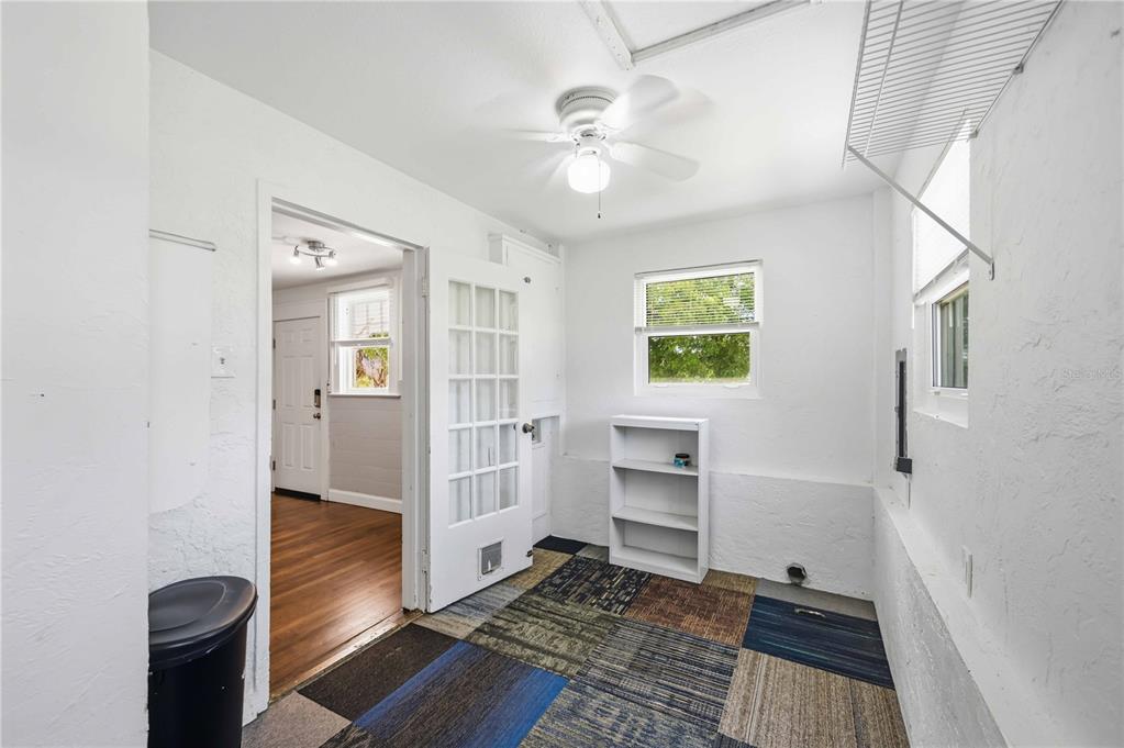 A laundry or utility room with a ceiling fan, white walls, and multi-colored carpet tiles — 815 SOLONA LOOP, PUNTA GORDA, FL