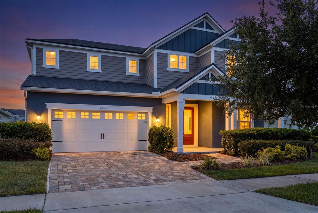 A covered front porch features a red door, two windows, and a potted plant — 2819 STONEGATE DRIVE, OCOEE, FL