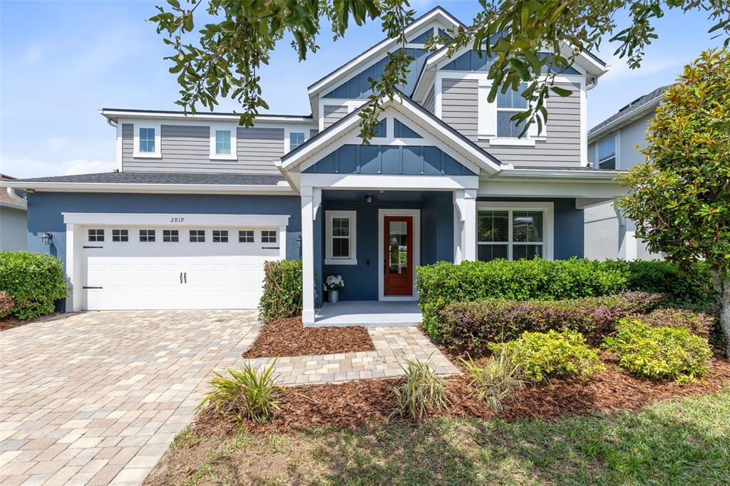 An open-concept living and dining area features a blue accent wall, tile floors, and kitchen — 2819 STONEGATE DRIVE, OCOEE, FL