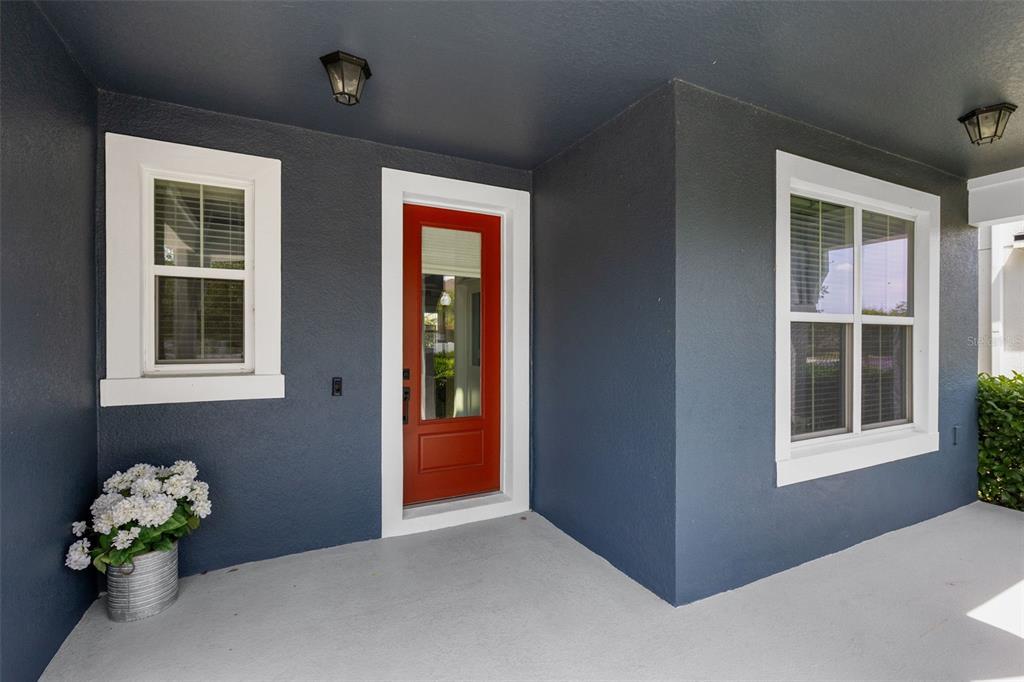 An open-concept living and dining area features gray tile flooring and a blue accent wall — 2819 STONEGATE DRIVE, OCOEE, FL