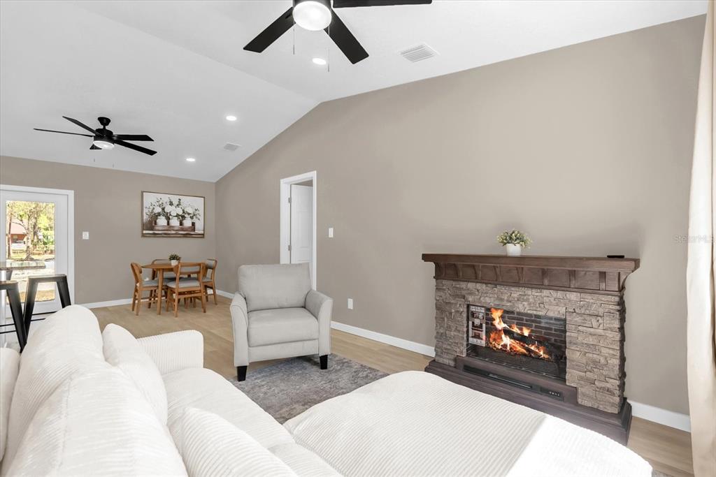 A living room features a stone fireplace, a gray armchair, and a dining area — 4840 MANGO AVENUE, COCOA, FL