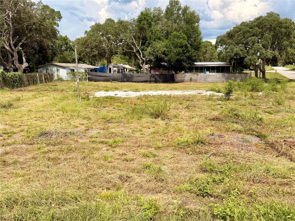 A vacant, grassy lot features a concrete foundation slab in a residential neighborhood — 18351 SE 20TH PLACE, SILVER SPRINGS, FL