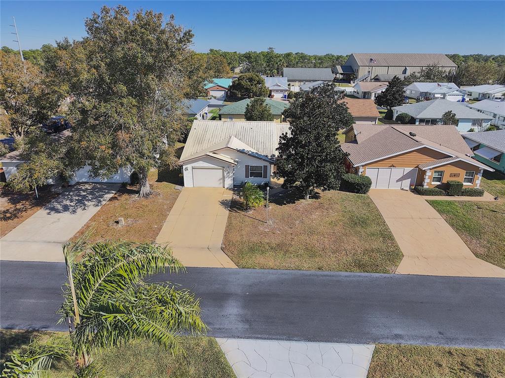 An aerial view shows two suburban houses with driveways and lawns on a sunny day — 1626 WILLOW RUN, SEBRING, FL