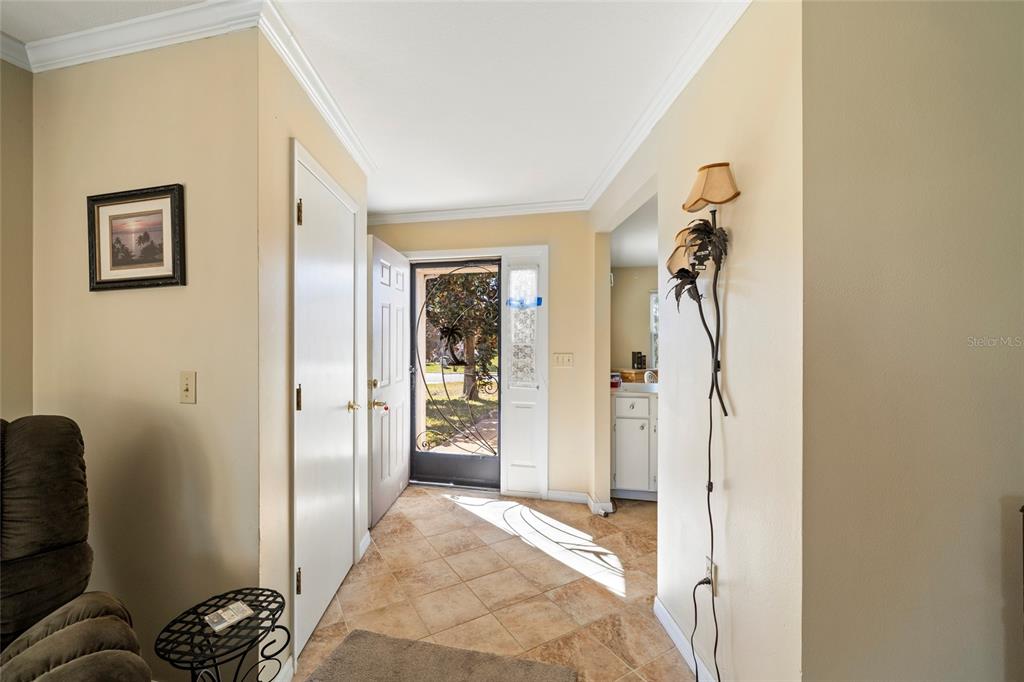 An entryway with tile flooring, a white front door, and a view of the outdoors — 1626 WILLOW RUN, SEBRING, FL