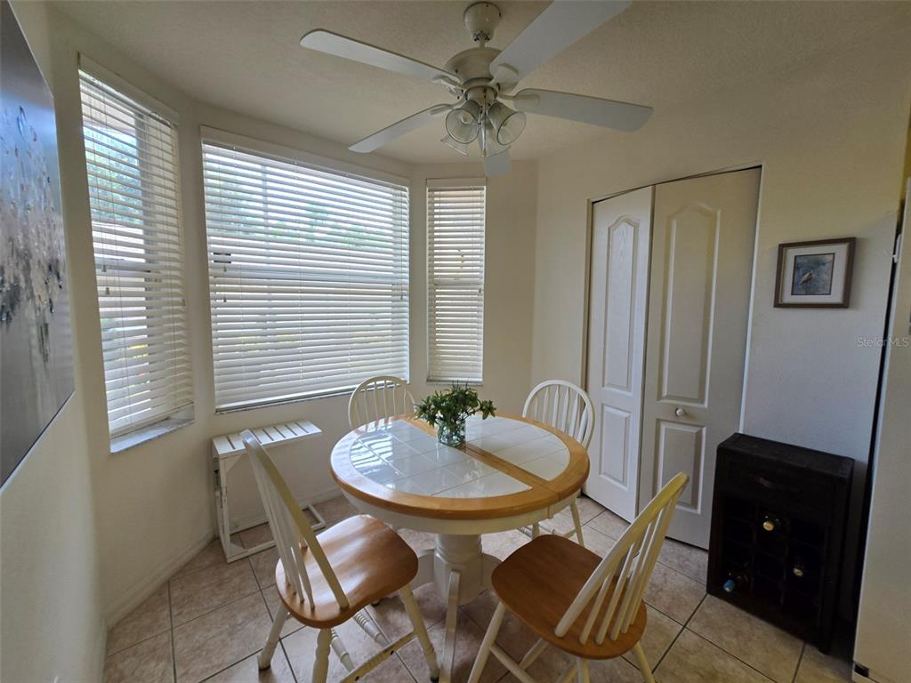 A dining nook features a round table, four chairs, tile flooring, and a ceiling fan — 5320 HYLAND HILLS AVENUE UNIT 2218, SARASOTA, FL