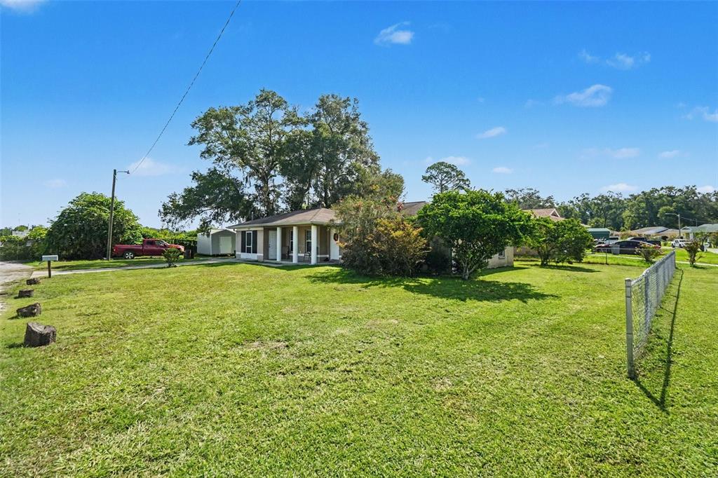 A single-story house with a covered porch sits on a large, grassy lot — 38638 PATTI LANE, DADE CITY, FL