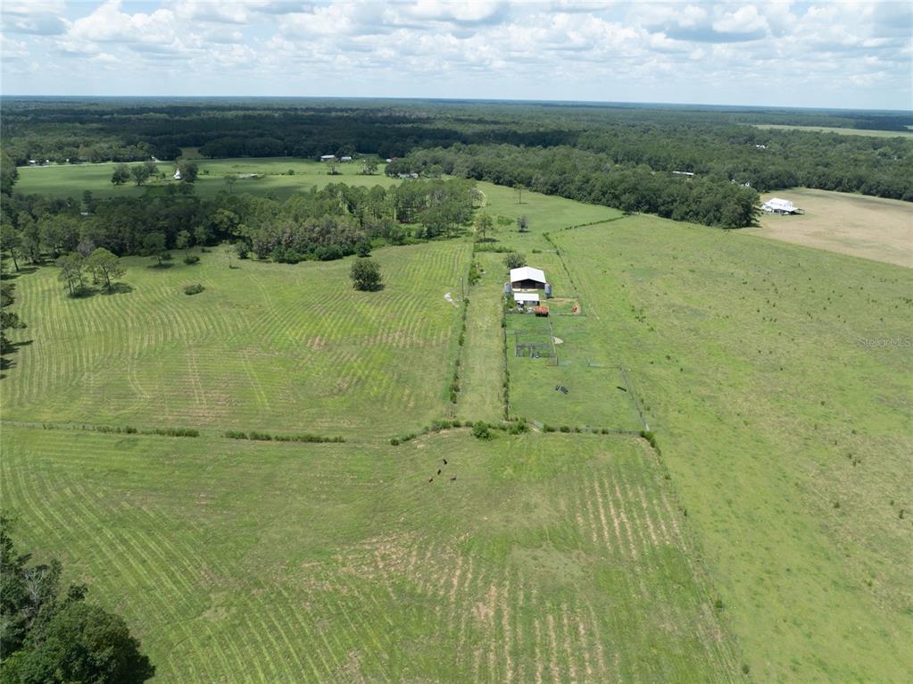 An aerial view shows a large rural property with a barn, fenced pastures, and trees — 0 NW CR 225, STARKE, FL