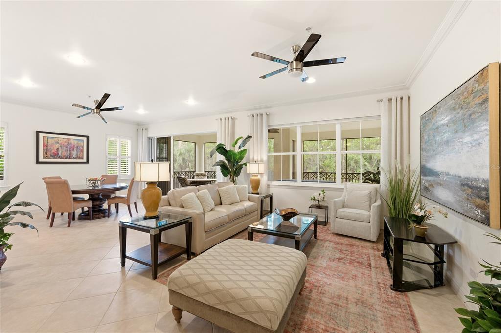 A spacious living and dining area features tile floors, neutral furniture, and large windows — 2843 TIBURON BOULEVARD E UNIT 7-102, NAPLES, FL