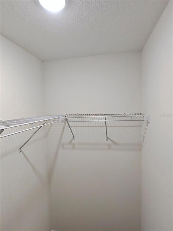 An interior view shows a living area with brown carpeting adjacent to a tiled kitchen — 527 HANSARE STREET SW, PALM BAY, FL