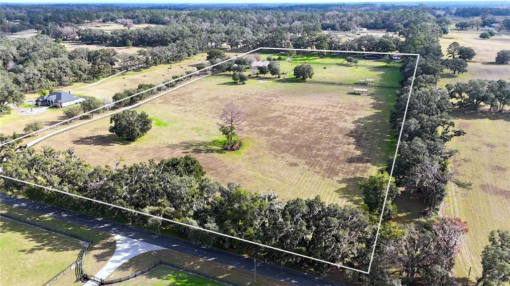 An aerial view shows a rural property with a house, barn, and fenced pastures — 9549 NW 80TH AVENUE, OCALA, FL