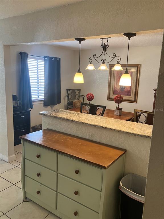 A light green dresser sits in front of a kitchen pass-through overlooking a dining area — 247 DEBORA COURT UNIT 247, ALTAMONTE SPRINGS, FL