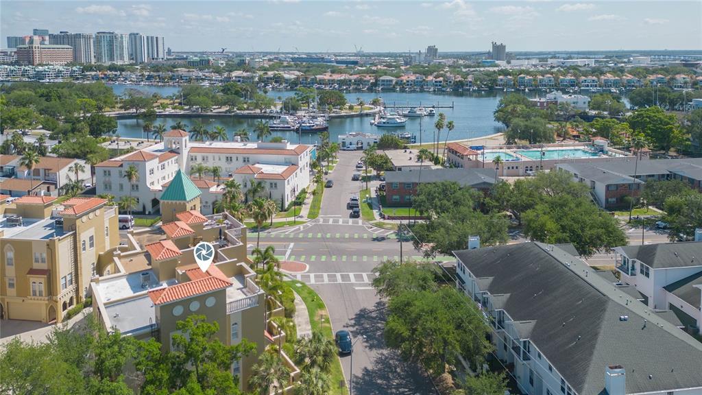An aerial view shows a multi-story building with a green roof and surrounding residential streets — 114 E DAVIS BOULEVARD UNIT 13, TAMPA, FL