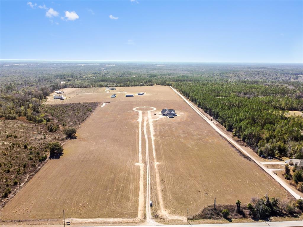 An aerial view shows a large, cleared lot with a house and a long driveway — 4299 ROYAL SKY (LOT 3) COURT, BROOKSVILLE, FL