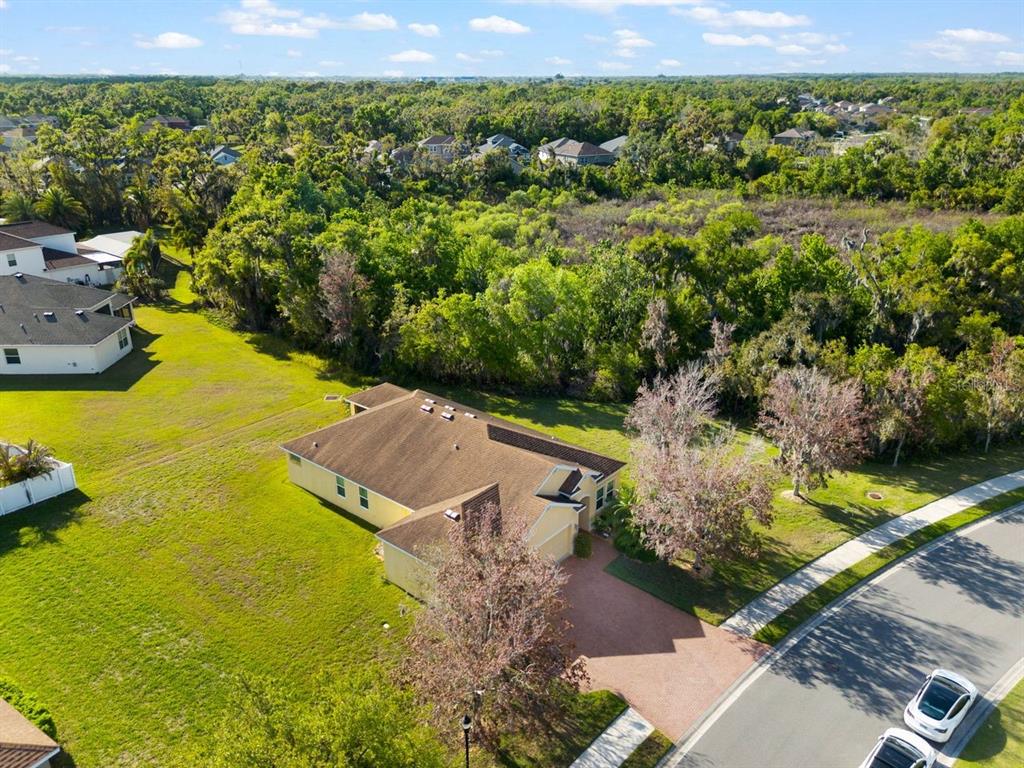 An aerial view shows a single-story house with a brown roof and a paved driveway — 5515 74TH PLACE E, ELLENTON, FL