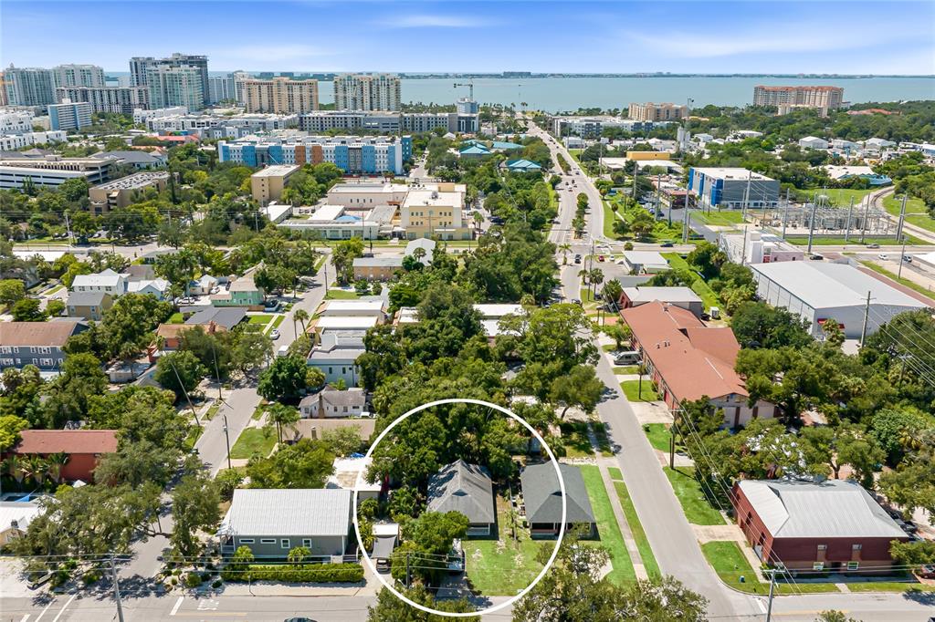 An aerial view shows a residential property with two houses surrounded by trees and streets — 919 GOODRICH AVENUE, SARASOTA, FL