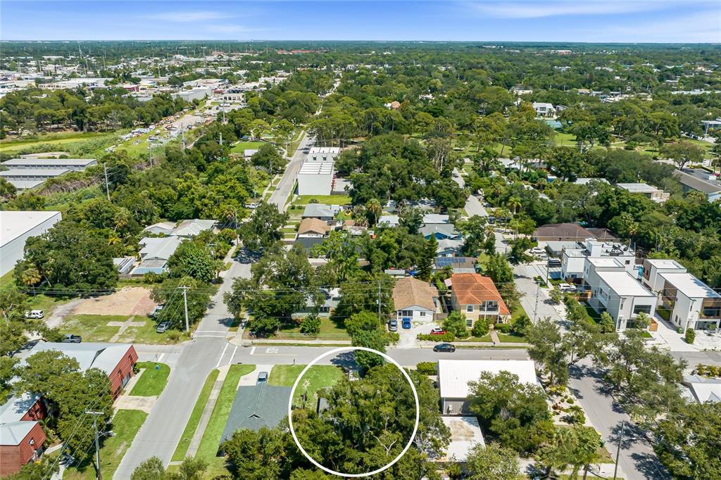 An aerial view shows a residential neighborhood with a circled lot containing dense trees — 919 GOODRICH AVENUE, SARASOTA, FL