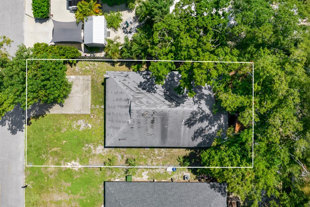 An aerial view shows a house with a gray shingled roof surrounded by mature trees — 919 GOODRICH AVENUE, SARASOTA, FL