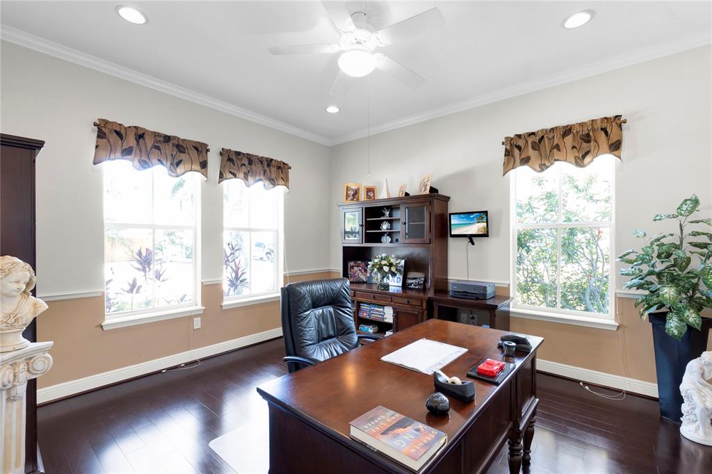 A dining room features a dark wood table, upholstered chairs, and a tray ceiling — 5727 SEA TROUT PLACE, APOLLO BEACH, FL