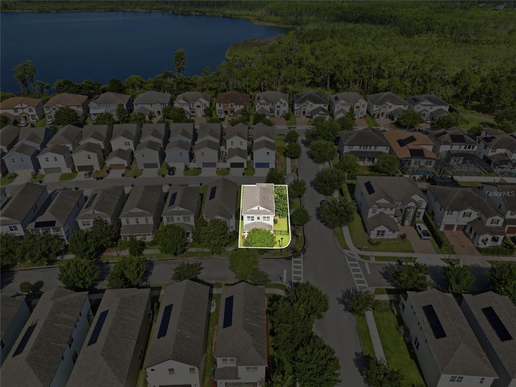 An aerial view shows a single-family home highlighted within a suburban residential neighborhood near water — 8266 BRYCE CANYON AVENUE, WINDERMERE, FL