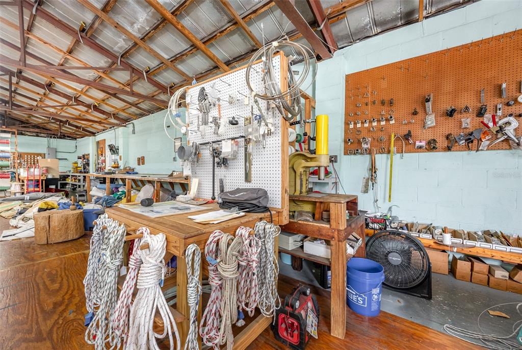 A workshop space features a wooden workbench, pegboard tool storage, and various ropes hanging below — 229 FORREST AVENUE, COCOA, FL