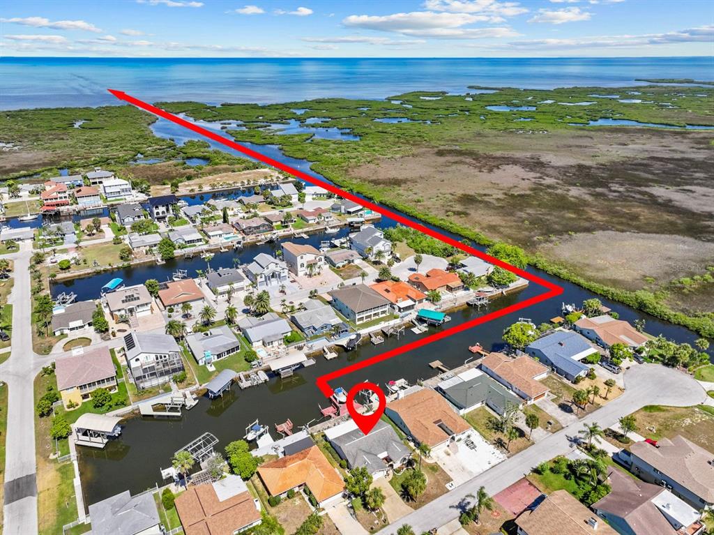 An aerial view shows a waterfront house with a red line indicating water access — 15639 BERTRAM DRIVE, HUDSON, FL