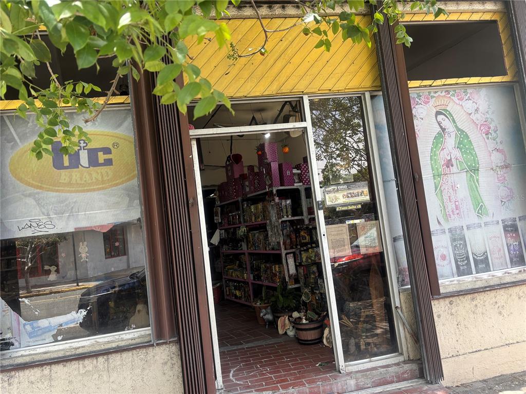 The exterior of a storefront features a yellow facade, glass windows, and an open doorway — 1001 PONCE DE LEON AVENUE UNIT 2, SAN JUAN, PR