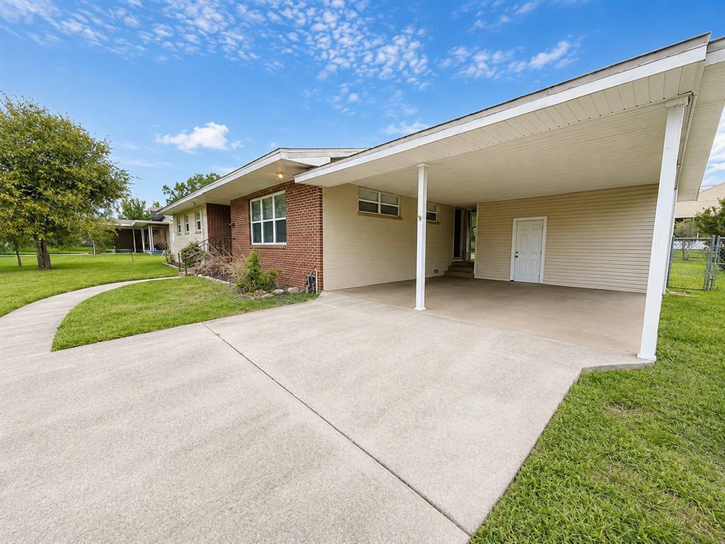 A kitchen with wood cabinets, dark countertops, stainless steel appliances, and a tile floor — 409 MONTGOMERY AVENUE, LAKELAND, FL
