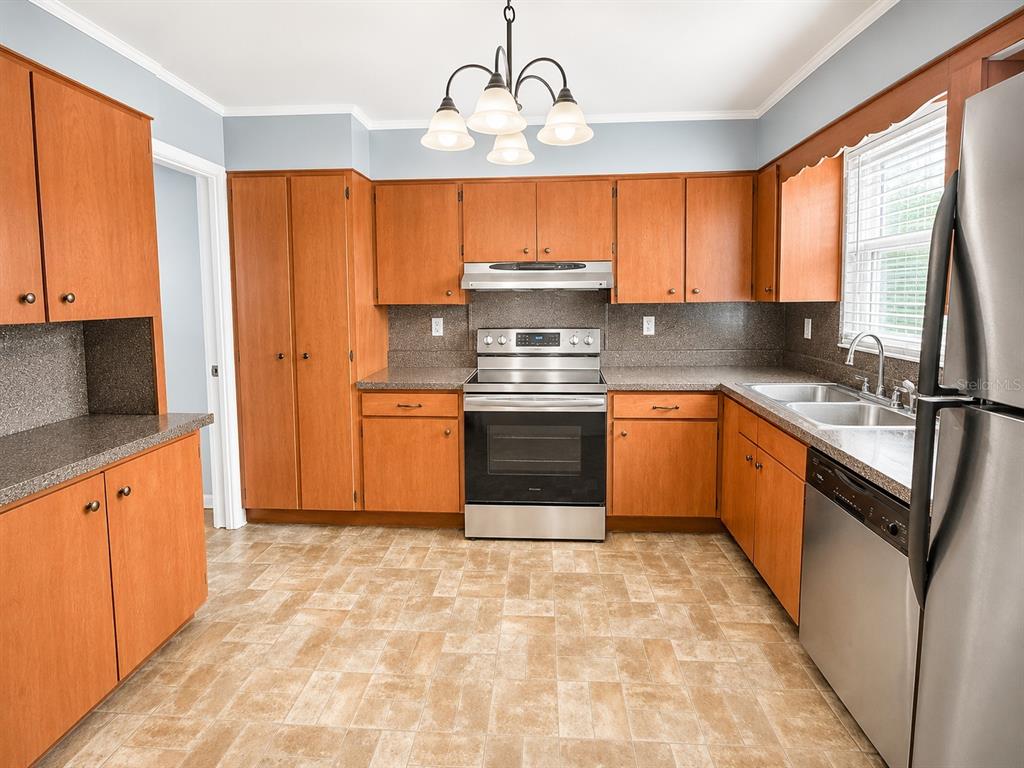 A living room features light tile flooring, a gray accent wall, and two ceiling fans — 409 MONTGOMERY AVENUE, LAKELAND, FL