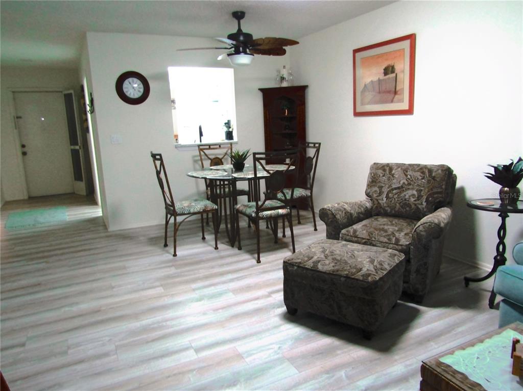 A dining and living area features wood-look flooring, a ceiling fan, and patterned furniture — 7050 W COUNTRY CLUB DRIVE N UNIT 10-A, SARASOTA, FL