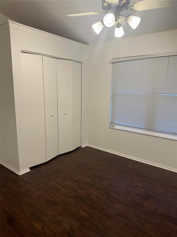 A bedroom with white walls, dark wood-look flooring, a ceiling fan, and a white closet — 1512 ISON LANE, OCOEE, FL