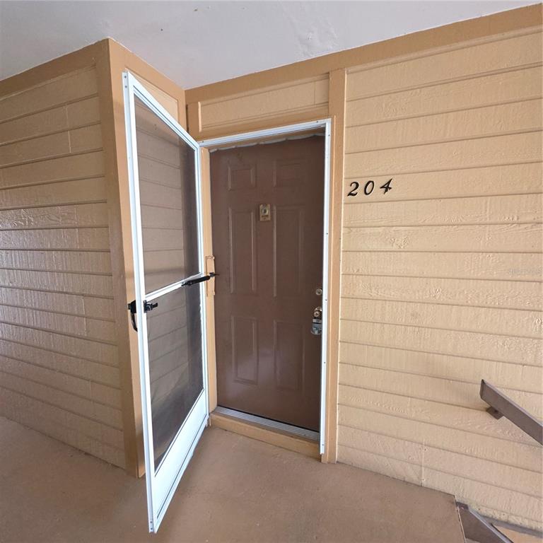 An empty bedroom features wood-look flooring, white walls, two windows with blinds, and a ceiling fan — 6031 SCOTCHWOOD GLEN UNIT 204, ORLANDO, FL