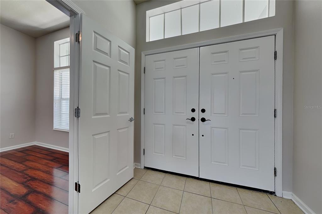 An entryway features a tiled floor, double front doors, and an open door to a room — 5714 99TH AVENUE CIRCLE E, PARRISH, FL