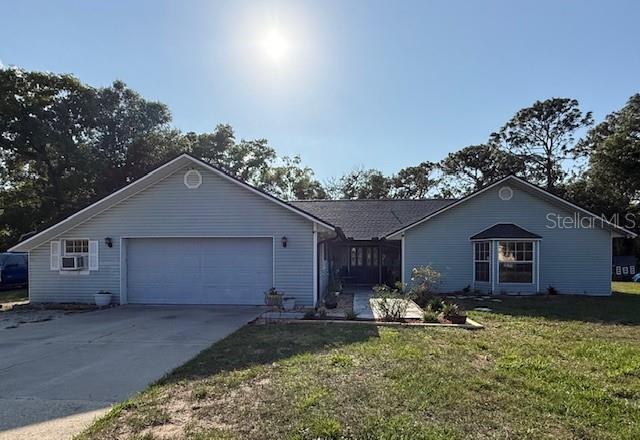 A light blue, single-story house with a gray shingled roof sits on a grassy lot — 40145 W 7TH AVENUE, UMATILLA, FL