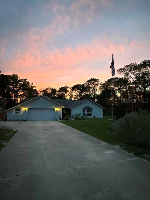 A kitchen features white cabinets, tile flooring, a stainless steel stove, and a breakfast nook — 40145 W 7TH AVENUE, UMATILLA, FL