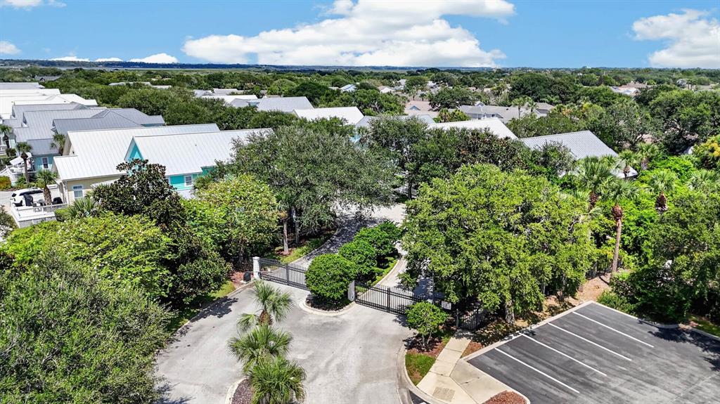 An aerial view shows a gated entrance leading into a residential neighborhood with coastal-style houses — 136 ISLAND COTTAGE WAY WAY, ST AUGUSTINE, FL