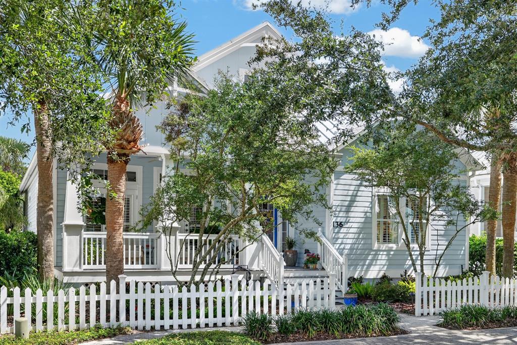 A light blue house with a white picket fence and a front porch — 136 ISLAND COTTAGE WAY WAY, ST AUGUSTINE, FL