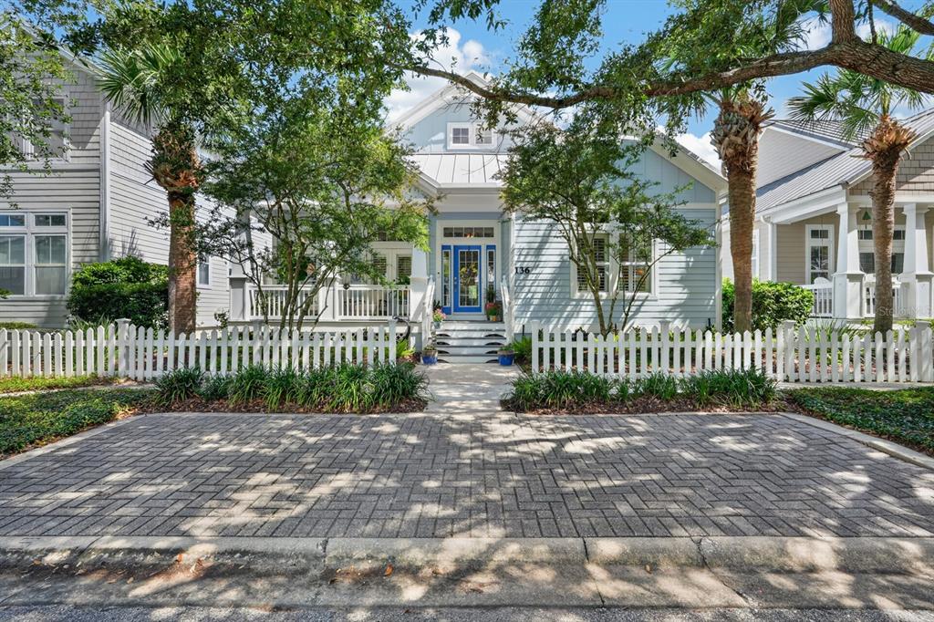 A light blue cottage with a white picket fence and a brick-paved driveway — 136 ISLAND COTTAGE WAY WAY, ST AUGUSTINE, FL
