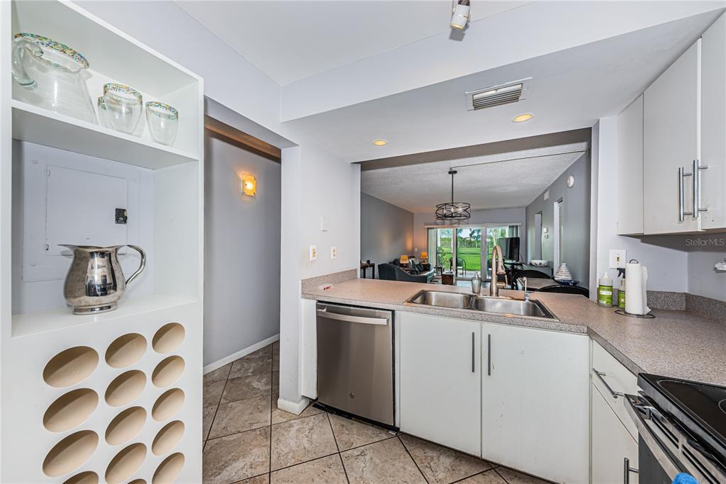 A kitchen with white cabinets, stainless steel appliances, and a built-in wine rack — 6269 PALMA DEL MAR BOULEVARD S UNIT 112, ST PETERSBURG, FL