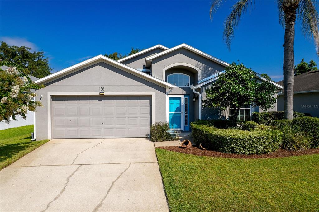 A single-story house with a gray exterior, a two-car garage, and a bright blue door — 138 BRIGHTVIEW DRIVE, LAKE MARY, FL
