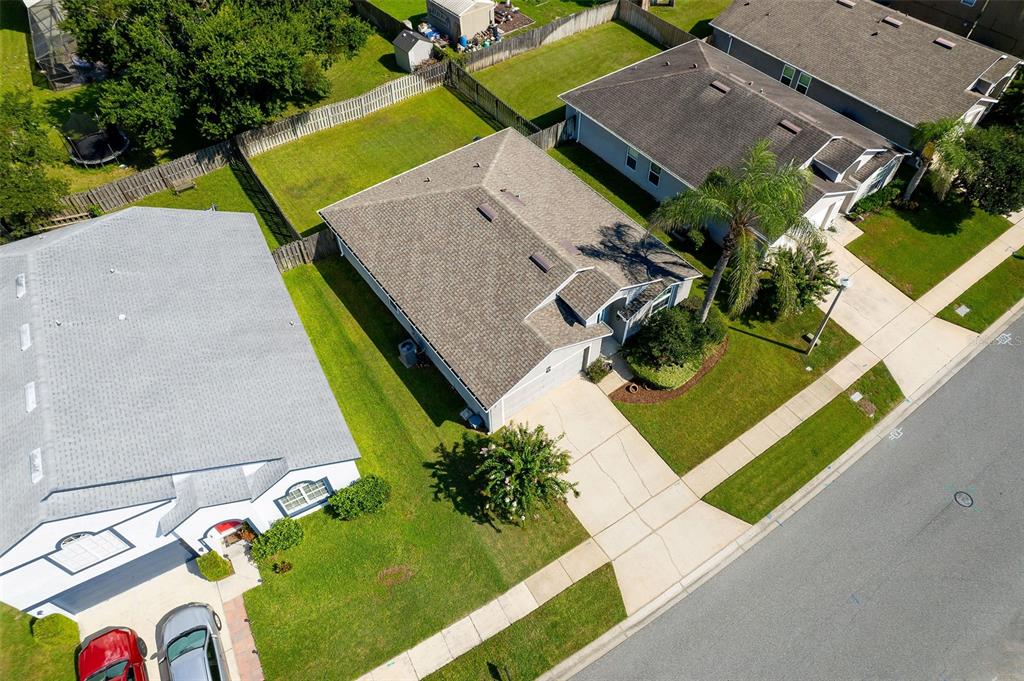 An aerial view shows a suburban house with a gray roof, driveway, and fenced backyard — 138 BRIGHTVIEW DRIVE, LAKE MARY, FL