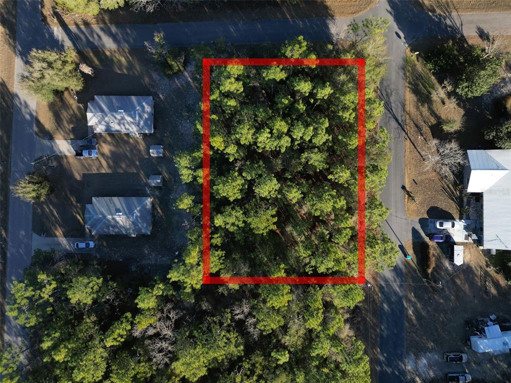 An aerial view shows a rectangular, tree-covered vacant lot outlined in red — 3153 E MAY STREET, INVERNESS, FL