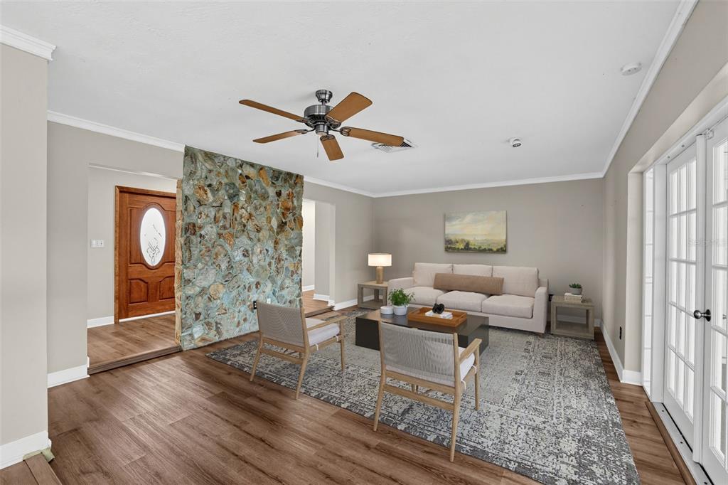 A living room features wood-look flooring, a stone accent wall, and glass-paned French doors — 6450 31ST TERRACE N, ST PETERSBURG, FL