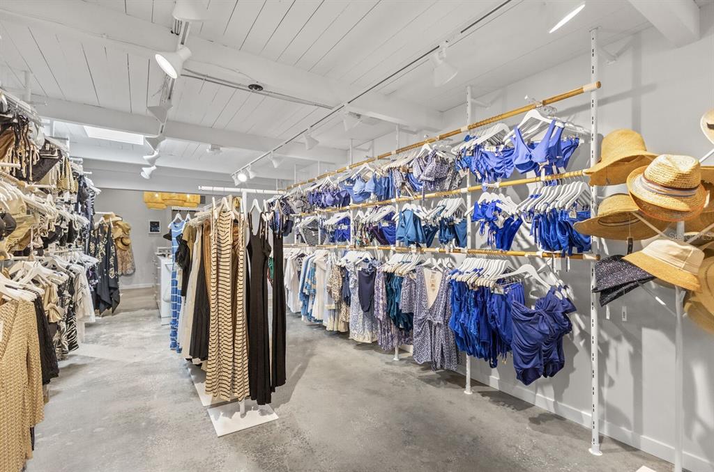 A retail clothing store features racks of swimwear, dresses, and hats under a white ceiling — 331 JOHN RINGLING BOULEVARD UNIT 101, SARASOTA, FL