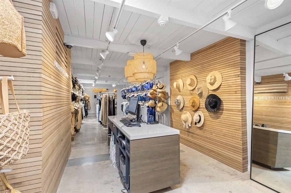 A retail boutique features wood-slatted walls, a central checkout counter, and hanging straw hats — 331 JOHN RINGLING BOULEVARD UNIT 101, SARASOTA, FL