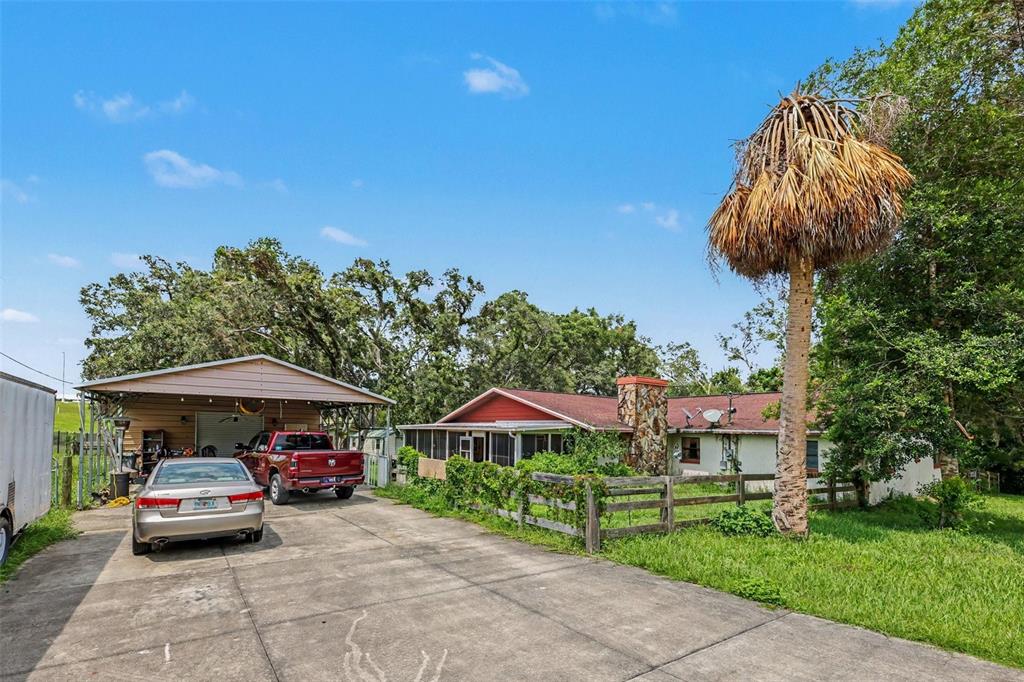 A single-story house with a carport, a red roof, and a stone chimney — 4611 W OLD CITRUS ROAD, LECANTO, FL